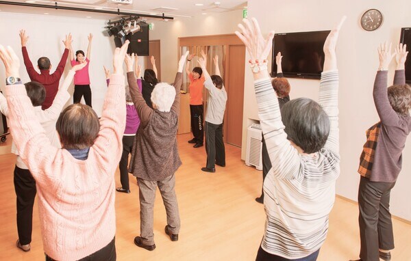音健士の指導で体を動かす高齢者 音健士の指導で体を動かす高齢者